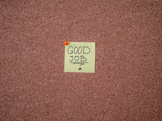 贴在布告栏上的附有工作文字的胶粘便条图片下载