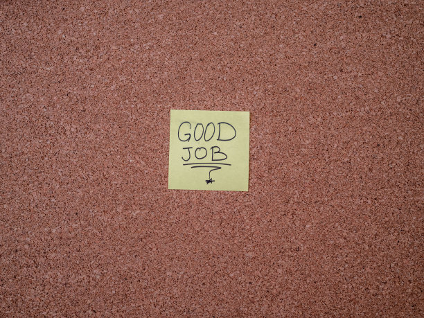 贴在布告栏上的附有工作文字的胶粘便条图片下载