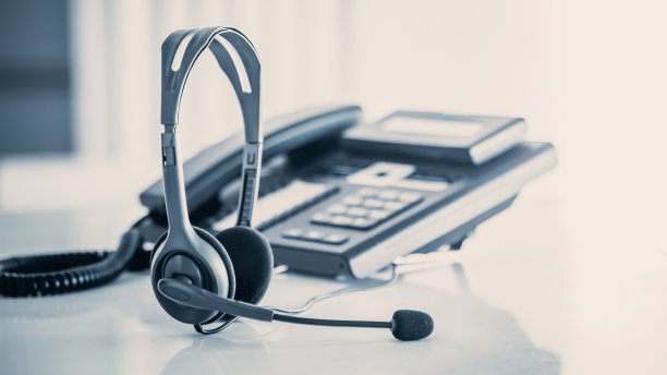 沟通支持，呼叫中心和客户服务帮助台。电话键盘上的VOIP耳机。图片下载