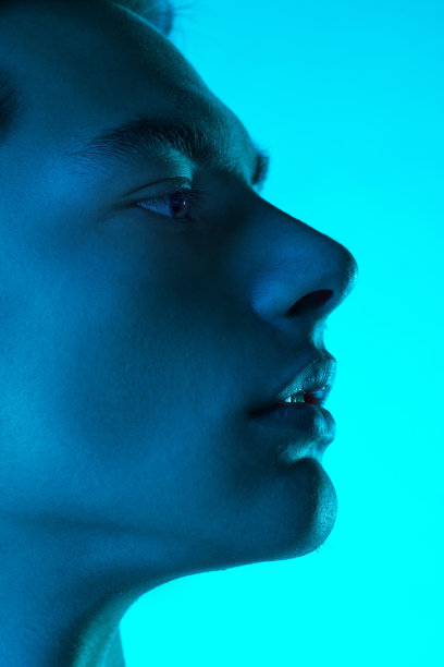 英俊的白人男子的肖像孤立在蓝色的工作室背景霓虹灯，单色图片下载