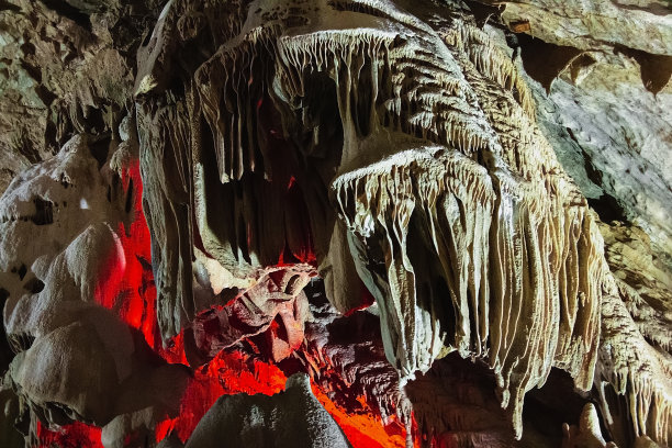 这是一个地下洞穴，有钟乳石和石笋，还有一个发光的陨石坑。图片下载