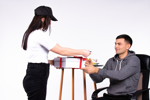 女士通过快递给男士送了一份礼物。白色背景上的照片。图片下载
