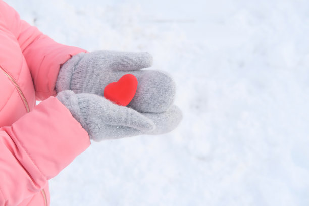 穿着粉色夹克的女孩拿着一个红心模型图片下载