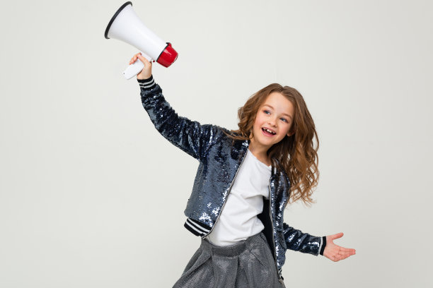 欧洲可爱微笑的少女拿着扩音器报道新闻，在白色的演播室背景上拿着扩音器图片下载
