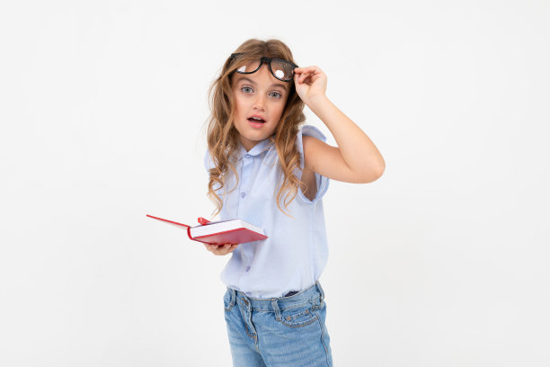 戴眼镜的聪明女孩在白色背景的笔记本上写字图片下载