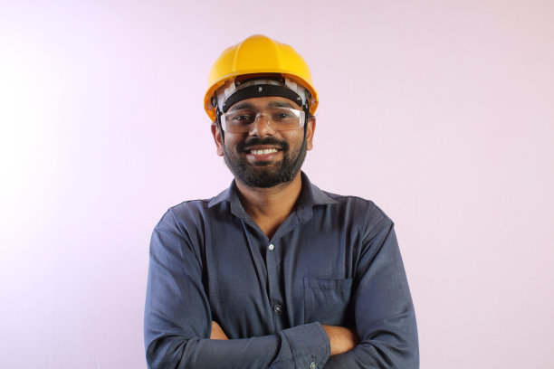 亚洲男性工程师在办公室检查和工作，并拿着设计图。她为工作开心地笑着图片下载