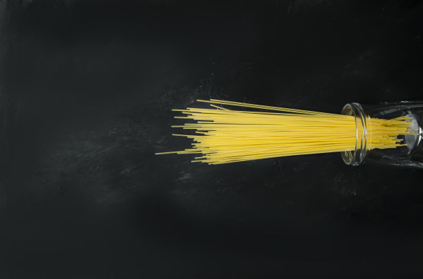 在灰色和黑色的背景上，从罐子里倒出意大利面图片下载