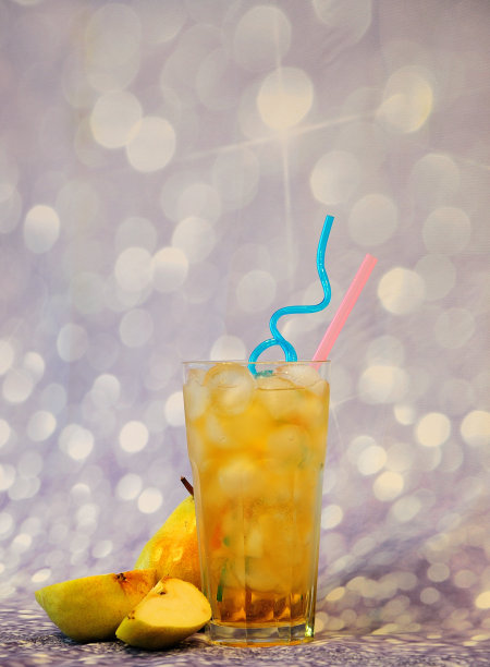 高脚杯的梨花蜜与冰和水果片在灰色光泽的背景。图片下载