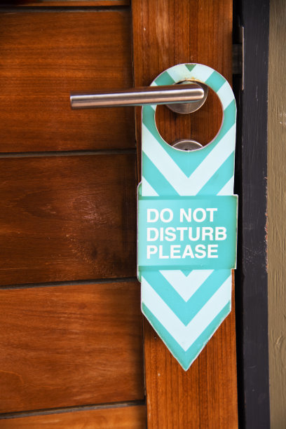 酒店房间的门上有一个请勿打扰的标志。图片下载