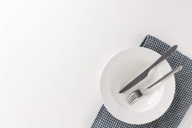 桌上放着白色的空盘子，还有刀叉和桌布。准备吃图片下载