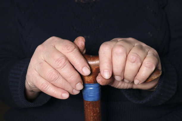 老妇人的手放在t形手柄的老拐杖上。老年、孤独、关怀、照顾老人的观念。图片下载