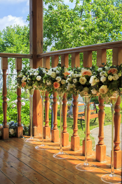 高大优雅的玻璃花瓶里的花朵点缀着乡间别墅的门廊图片下载