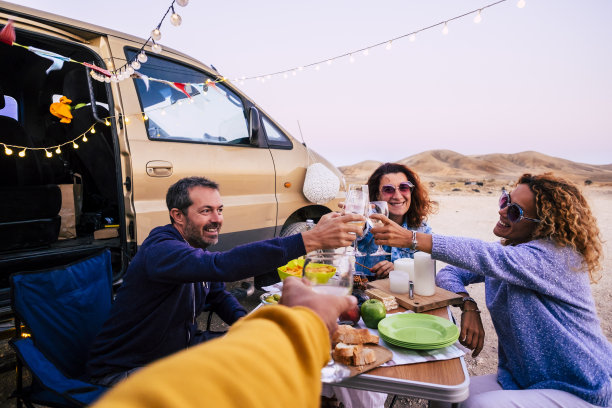 一群成年白人朋友享受和庆祝在友谊的户外与桌子和食物和货车周围-愉快和祝酒在假期午餐图片下载