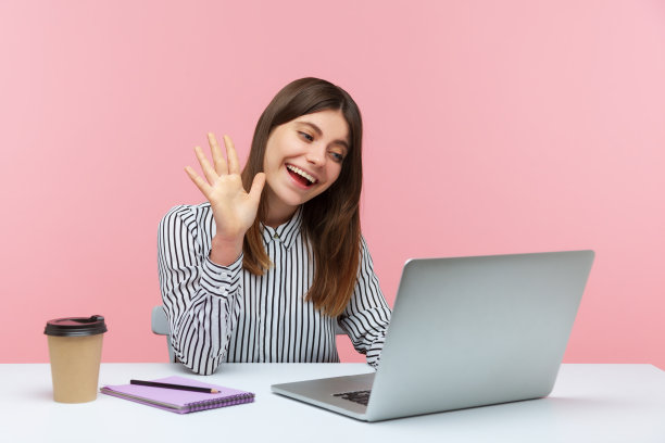 友好的商务女性向笔记本电脑屏幕挥手，与朋友进行视频通话，在家办公进行在线会议图片下载