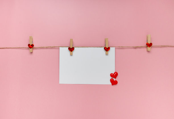 白色卡片和粉红色背景上的心。横幅。情人节的概念。俯视图，复制空间图片下载
