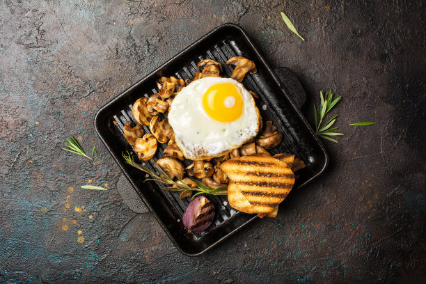 煎蛋和烤香菇放在铸铁煎锅或平底锅上，加香料图片下载