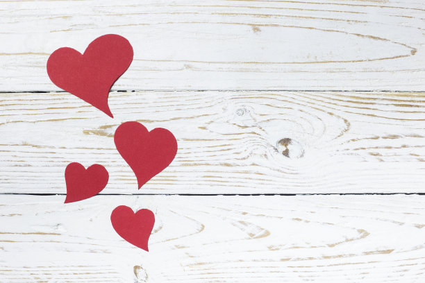 4颗不同大小的心形用红色做成的白色木板复古风格。与副本的空间和文本。婚礼请柬，情人节或浪漫关系。图片下载