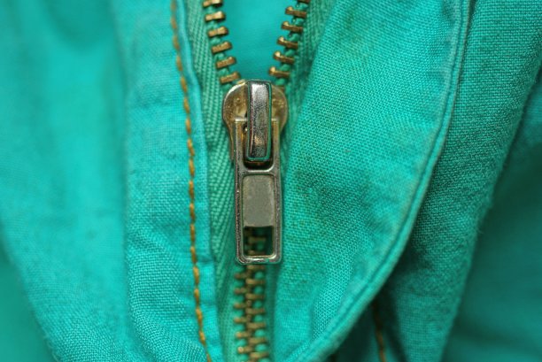 绿色织物纹理与棕色金属拉链图片下载