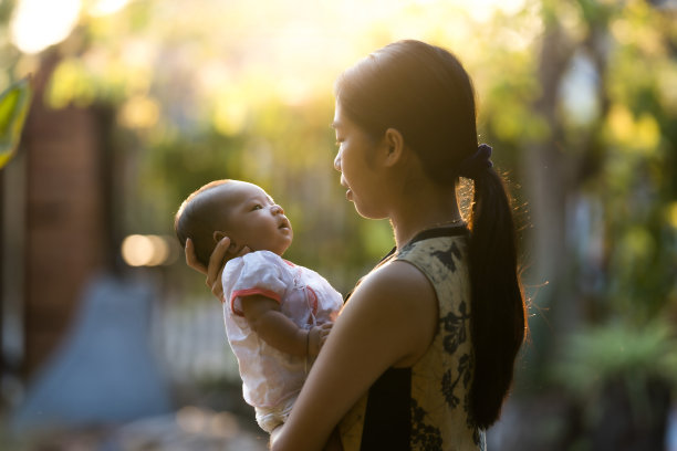 在温暖的晨光中，婴儿和一位亚洲母亲在一起。图片下载