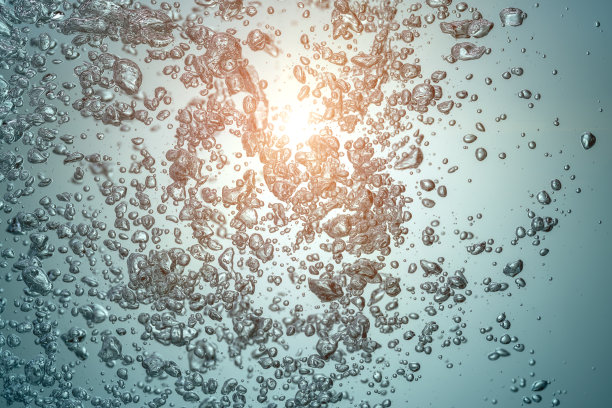 太阳从带着泡泡的蓝色海水中钻了出来。图片下载