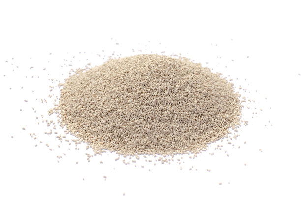 白色背景上分离的干酵母堆，俯视图。白色背景上的活性干酵母，俯视图。在白色背景下分离的干酵母颗粒。干酵母用于烘焙食品。图片下载