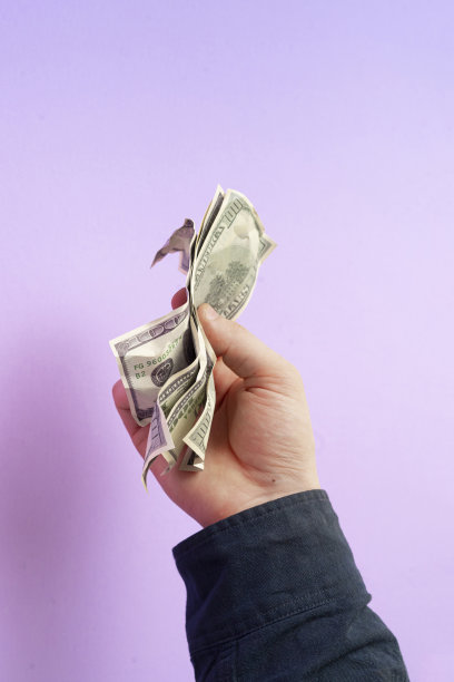 手里拿着一美元钞票，映衬着色彩的背景，简单赚取极简的概念图片下载