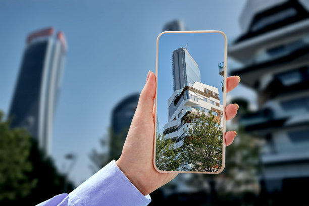 一个女人手里拿着一部智能手机，上面有大都市和蓝天的照片。图片下载