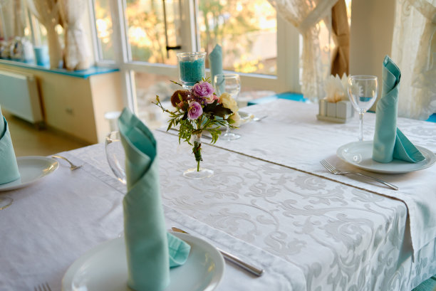 餐厅、复印区婚宴桌上，花瓶上插花玫瑰和绿叶植物。豪华婚礼装饰。表设置图片下载