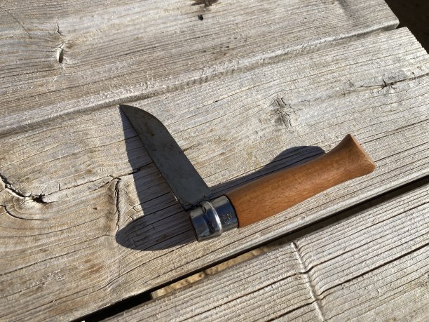 木桌上的折叠小刀，木柄半开图片下载
