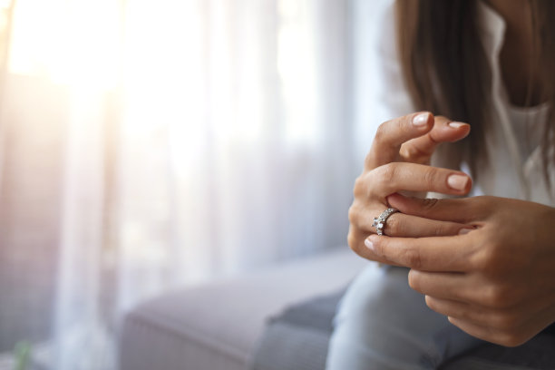 沮丧悲伤的年轻女子妻子独自坐着手里拿着订婚戒指感觉心烦意乱图片下载