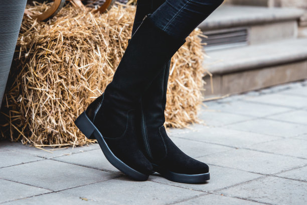 女孩腿在一个黑色绒面革冬季靴子。街头的照片图片下载