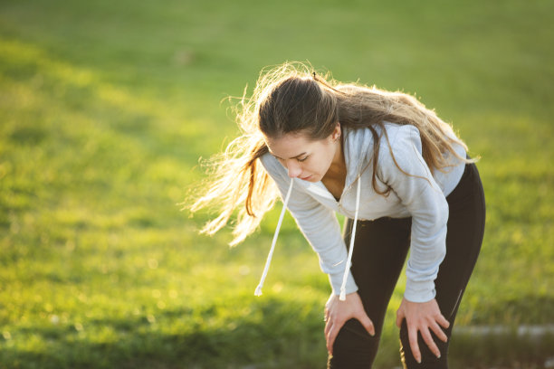 精疲力竭的运动员在公园擦拭额头图片下载