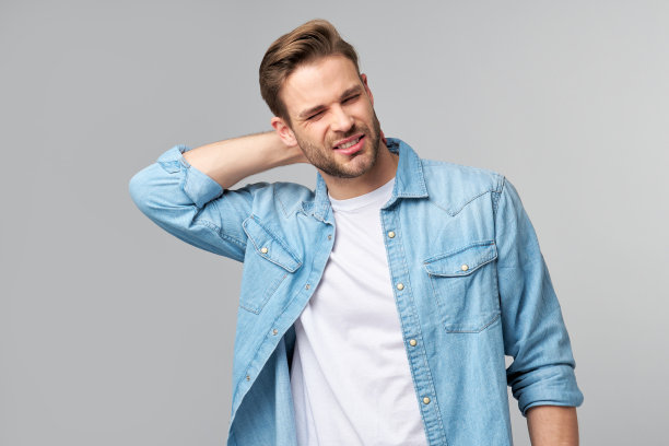 年轻英俊的男子与颈部油漆站在灰色背景图片下载