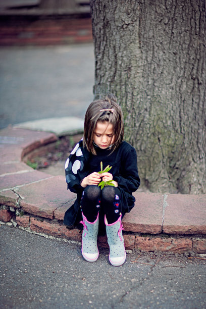 抱着绿叶的悲伤女孩的肖像图片下载