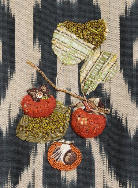 伊卡特布料上的柿子刺绣。水果静物图片下载