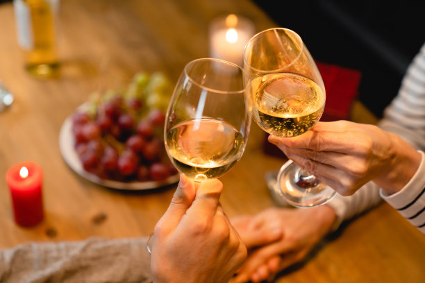 在浪漫晚餐的背景下，酒杯碰杯的剪裁照片图片下载