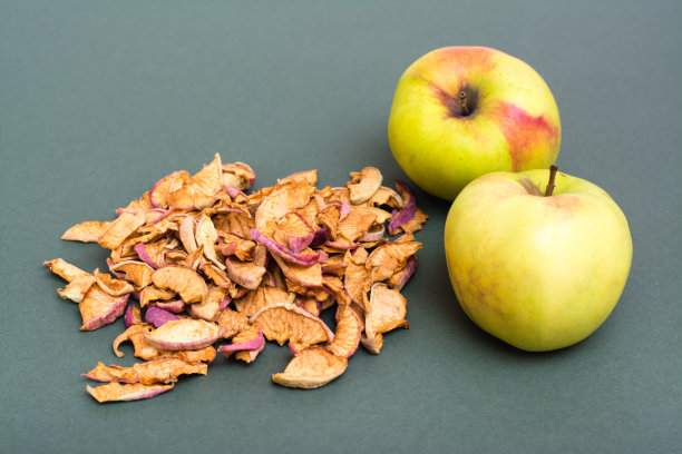 一把干苹果和新鲜苹果在绿色的背景图片下载