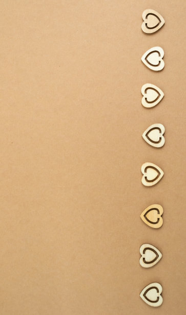 木心在粉彩工艺纸背景。抽象背景与木材切割形状。圣瓦伦丁，母亲节，生日贺卡，请帖。副本的空间。图片下载