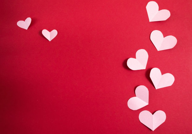 红色背景上不同大小的纸心。抽象的背景与剪纸形状。圣瓦伦丁，母亲节。生日贺卡，请柬。模板的设计。副本的空间。图片下载