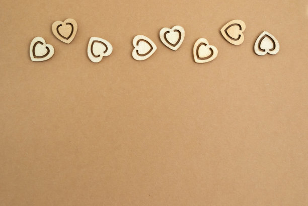 木心在粉彩工艺纸背景。抽象背景与木材切割形状。圣瓦伦丁，母亲节，生日贺卡，请帖。副本的空间。图片下载