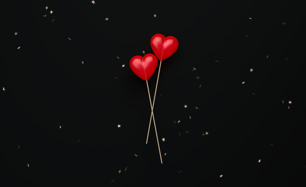 情人节概念-星星形状的五彩纸屑在黑色背景上落在心形棒棒糖上图片下载