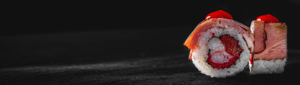 寿司、鱼和米饭放在黑色的木桌上图片下载