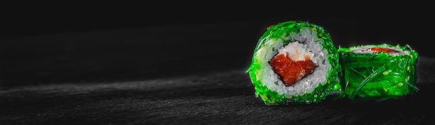 寿司、鱼和米饭放在黑色的木桌上图片下载