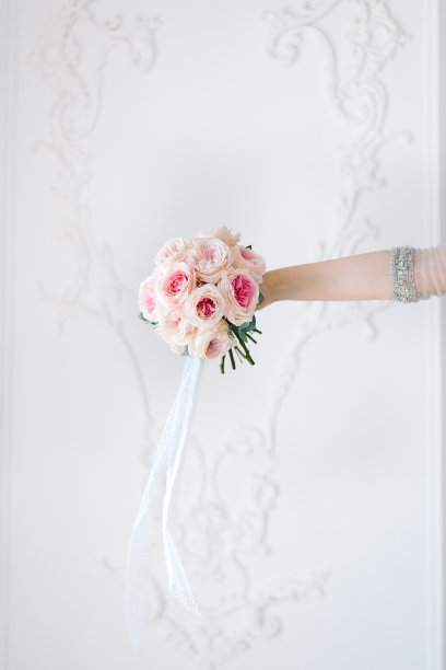 美丽古典的婚礼花束在新娘的手中。粉色牡丹玫瑰。图片下载