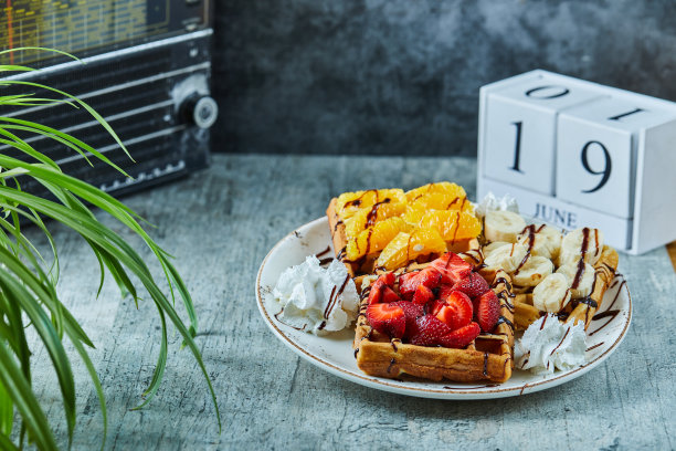 大理石背景上的白色盘子里有冰淇淋、香蕉、草莓、巧克力的华夫饼图片下载