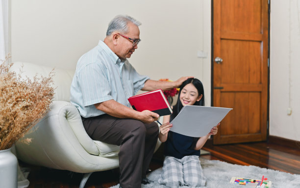 奶奶开心地笑了，可爱的孙子坐在客厅里。图片下载