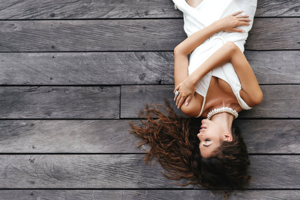 照片美丽的女士在白色的连衣裙躺在木地板，夏天的配件。图片下载