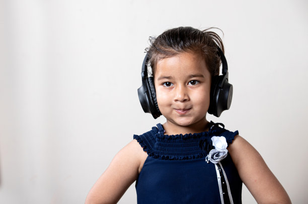 可爱的小女孩戴着耳机听音乐，表情可爱图片下载