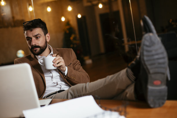 年轻商人在办公室喝咖啡。图片下载