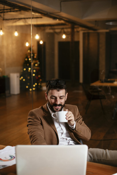 年轻商人在办公室喝咖啡。图片下载